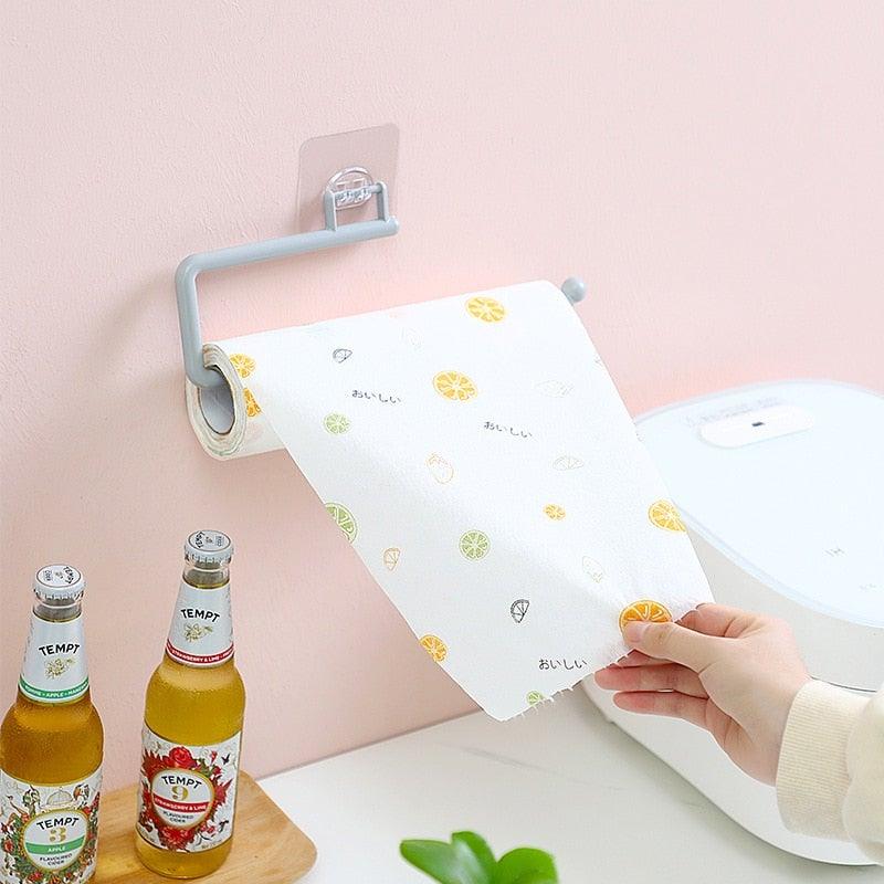 Gray wall-mounted paper roll holder carrying a printed white roll against a pale pink wall.